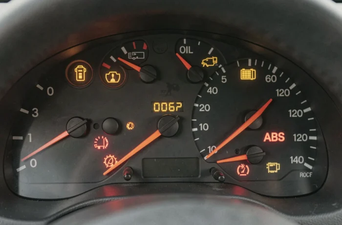 Gros plan sur les voyants d'avertissement illuminés du tableau de bord d'une Peugeot 206